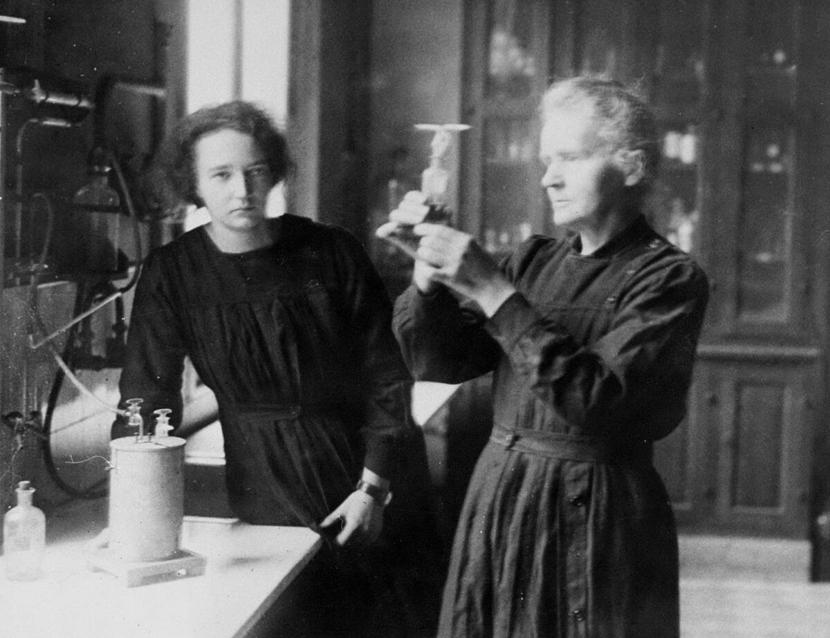Scientist Marie Curie and daughter, Irene, working in the ra