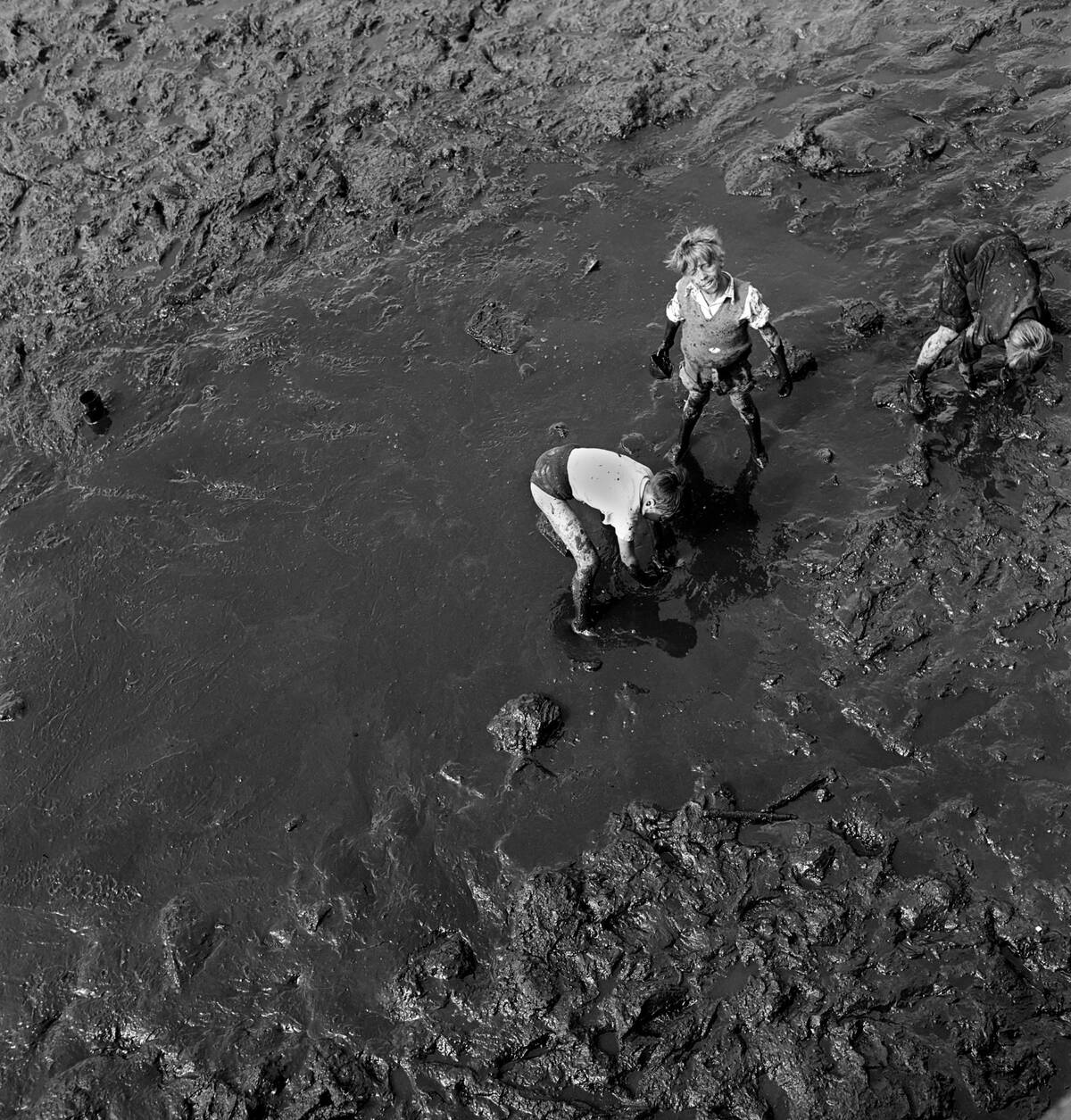 The mud-larkers: These boys at Portsmouth Harbour do a mud-lark turn to get pennies from visitors crossing the bridge to