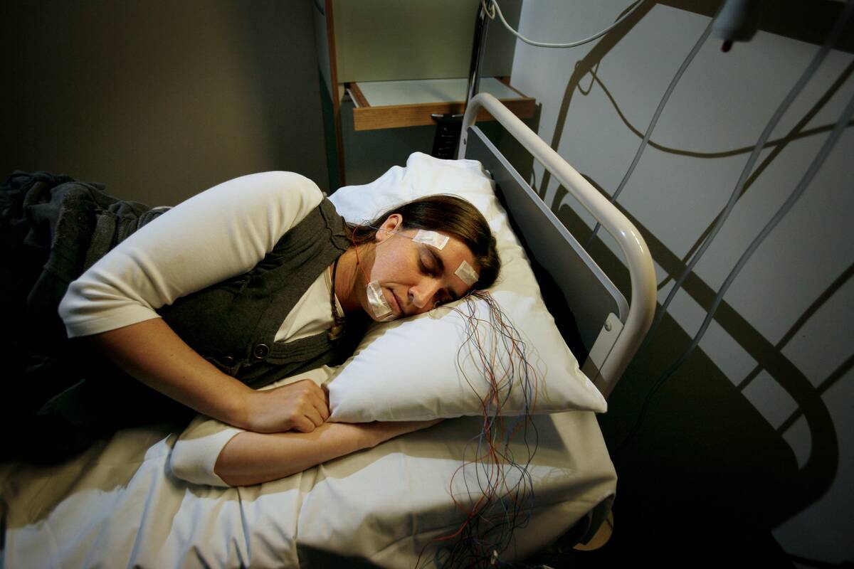 A patient, who appears to be asleep, is photographed at a sl