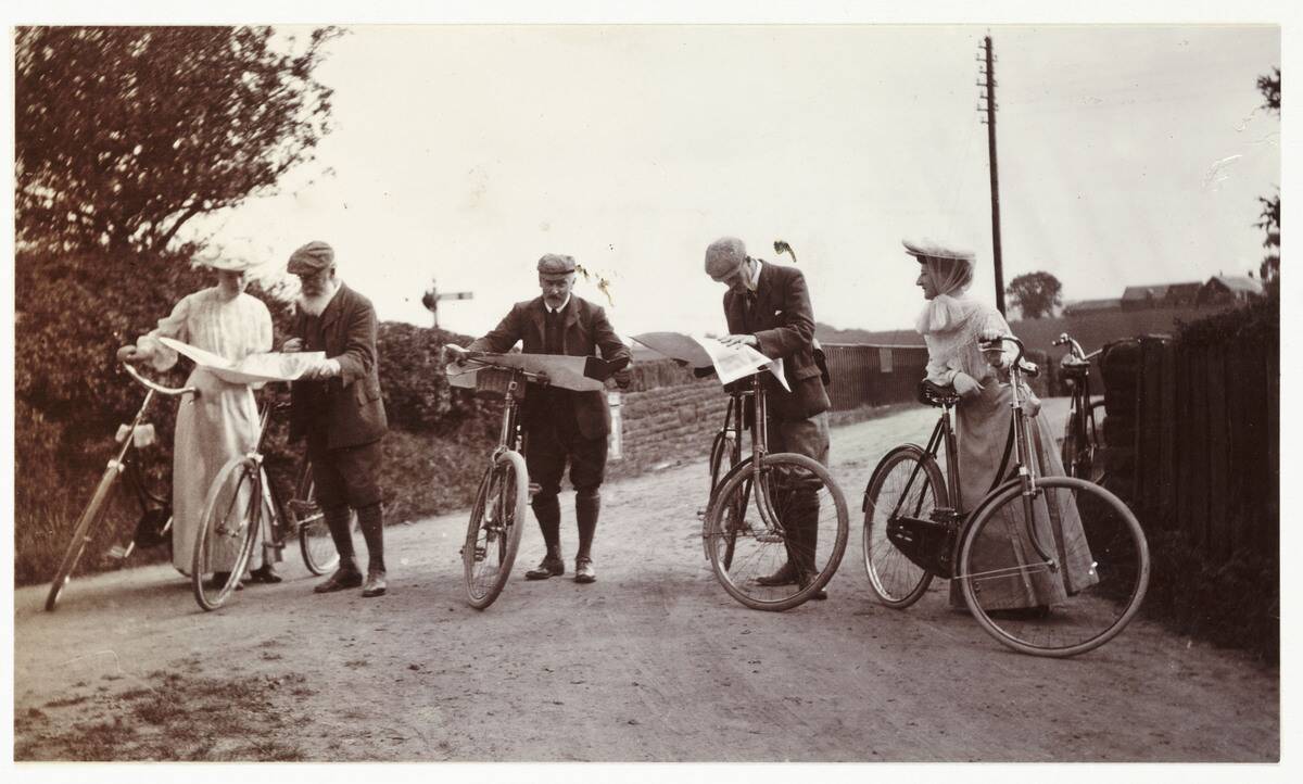 Cyclists looking at maps, c 1900.