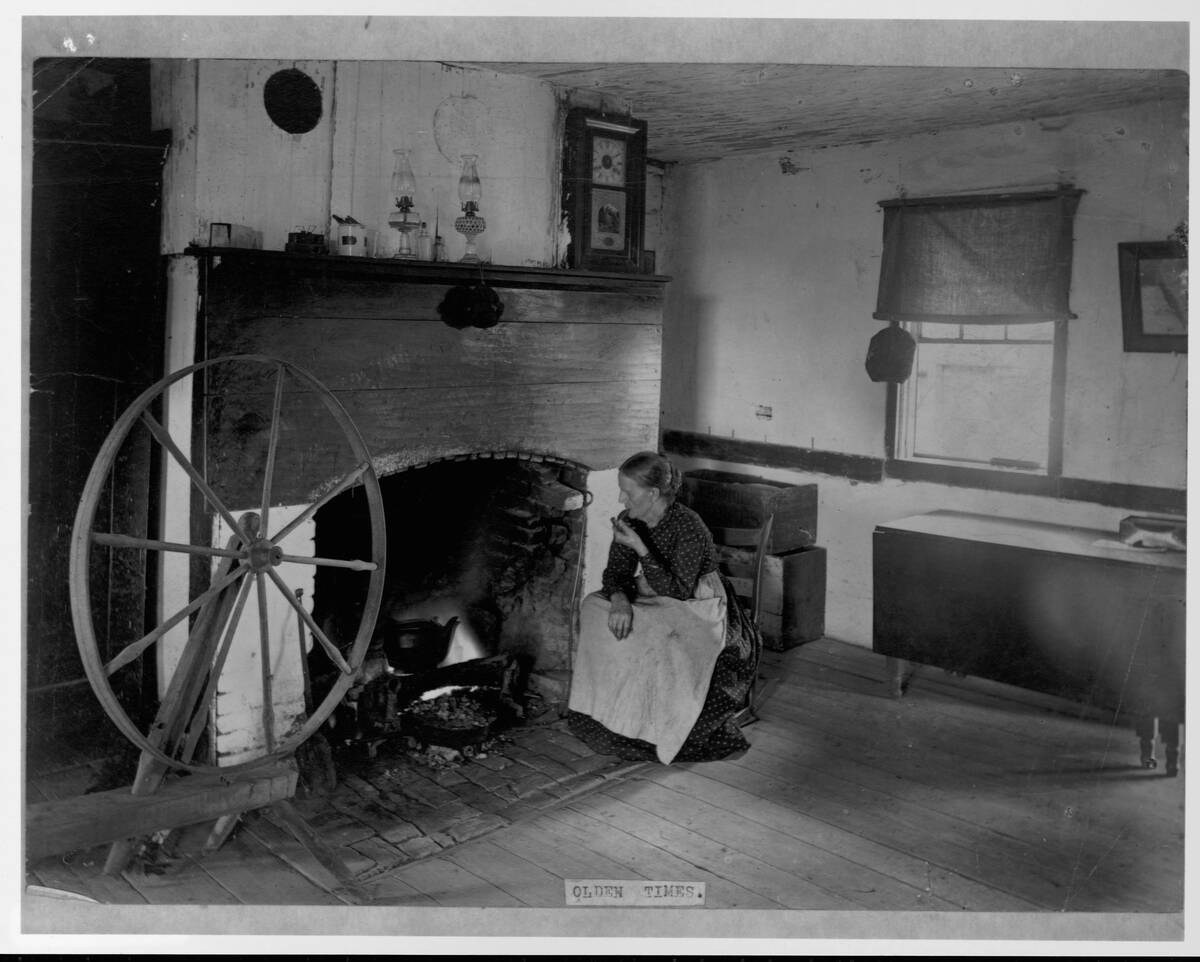 Elderly Woman Smoking Pipe by Fireplace