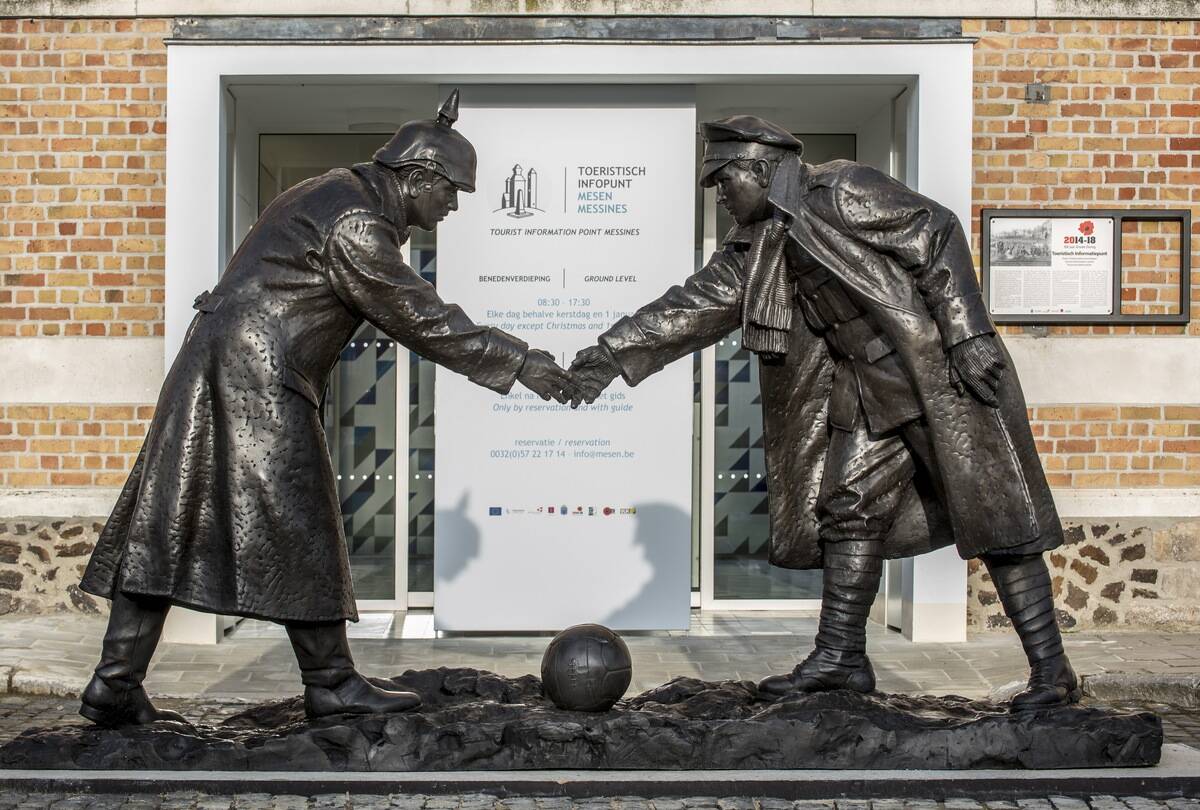 Statue by Andrew Edwards representing British and German soldiers shaking hands during World War One Christmas Truce in front of the Mesen / Messines tourist information point