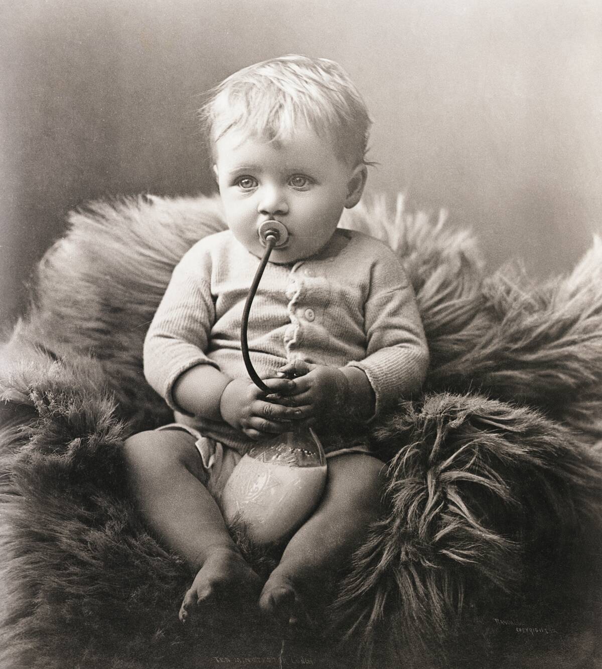 Baby Boy on Bear Rug Sucking on Milk Bottle