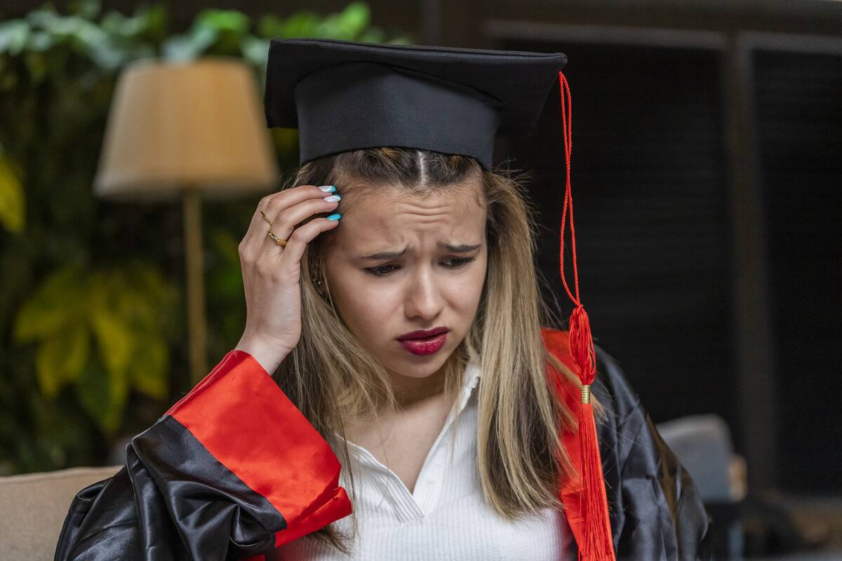 worried-woman-in-graduation-gown-inside-home-2026-01-07-23-33-55-utc