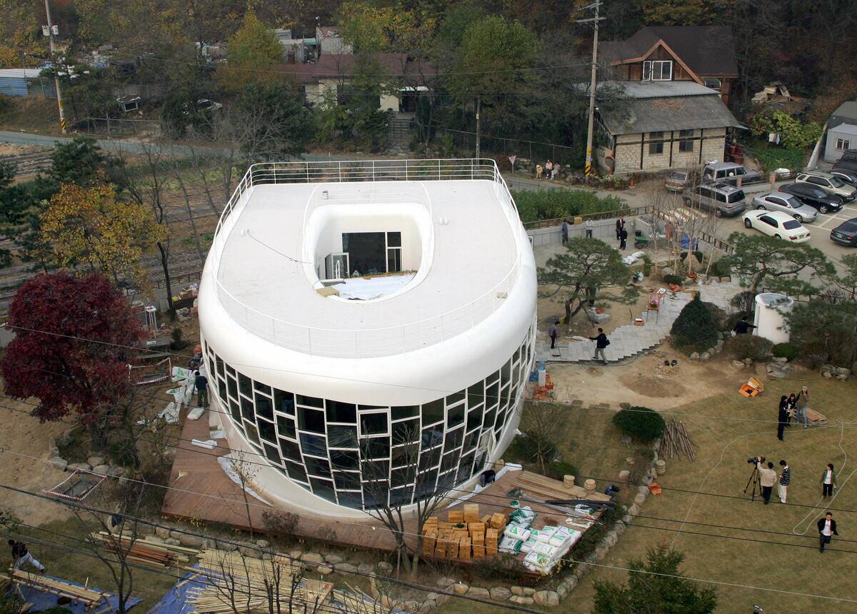 A steel and glass toilet-shaped house is