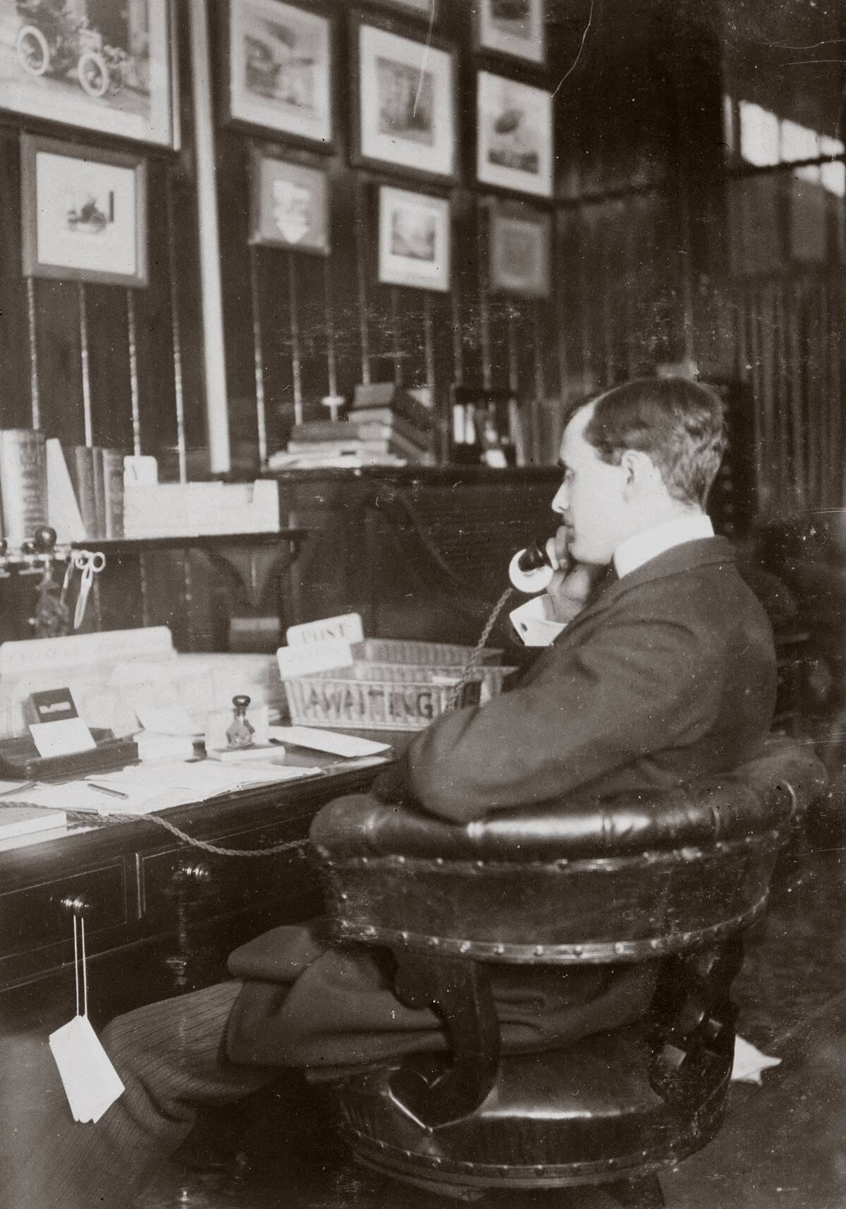 C S Rolls sitting at his desk talking on the telephone, c 1900.