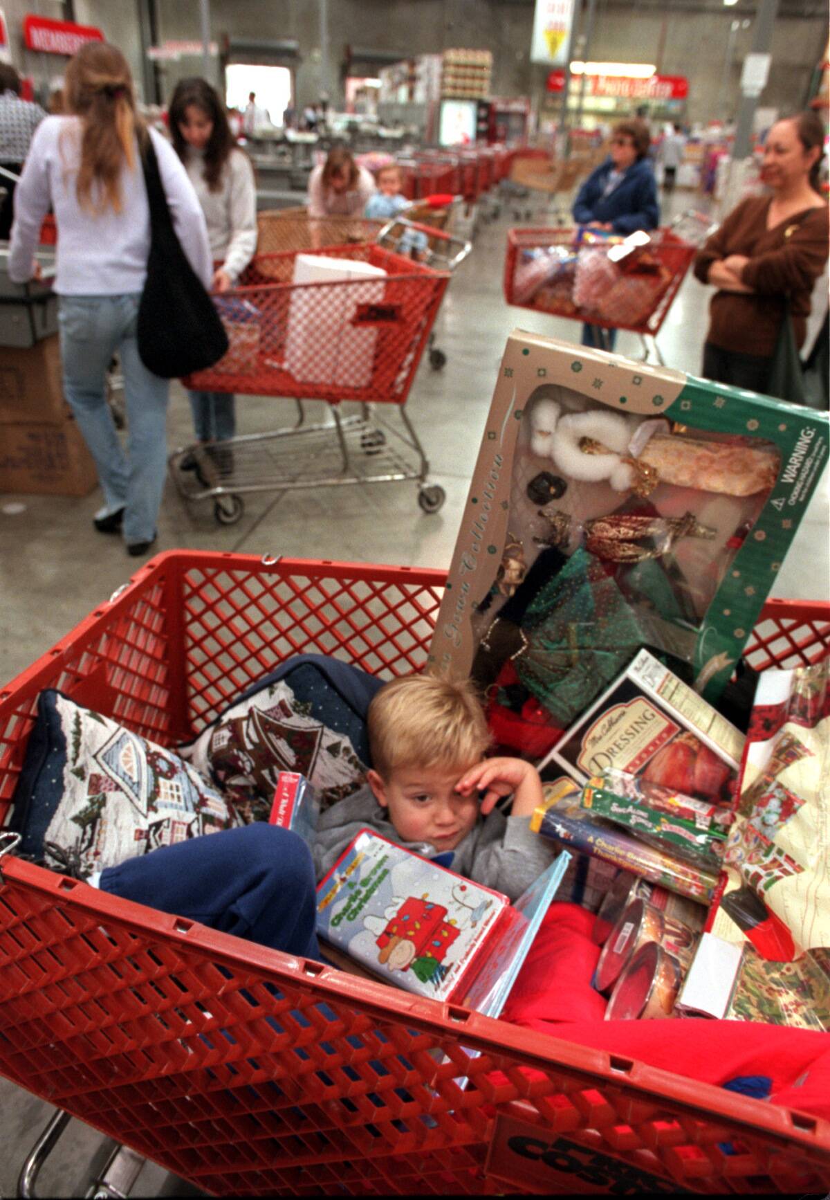 Matthew Litchfield, 3, sits in his mother's shopping cart filled with items from Costco in Westlake