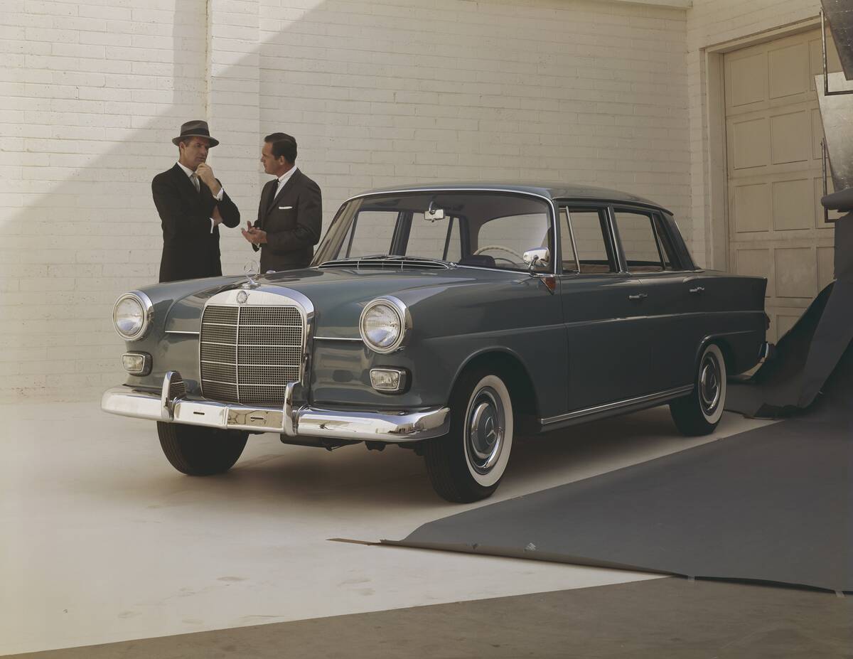 Men standing beside car and talking