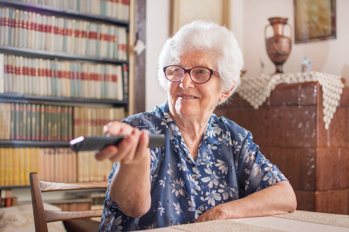 smiling-senior-woman-holding-remote-control-indoor-2026-03-05-11-38-07-utc