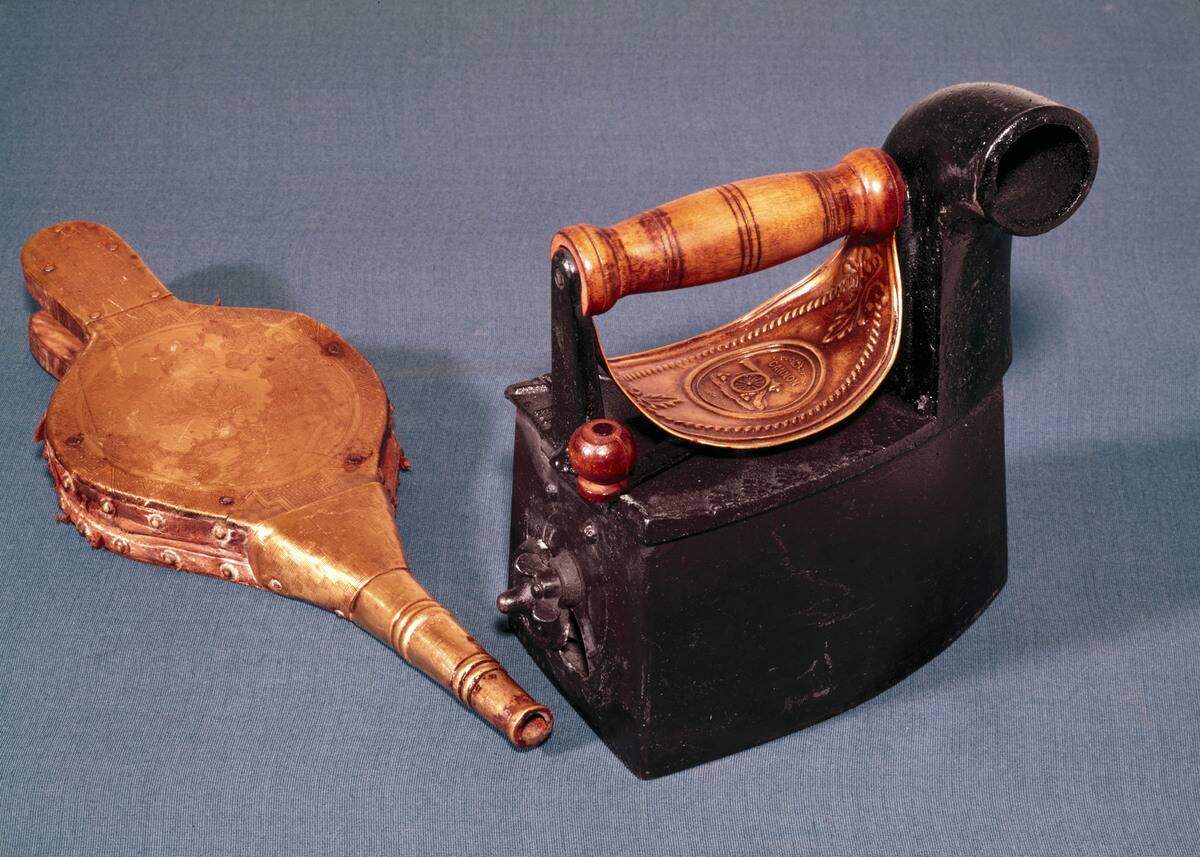 Cannon charcoal heated flat-iron and bellows, c 1850.