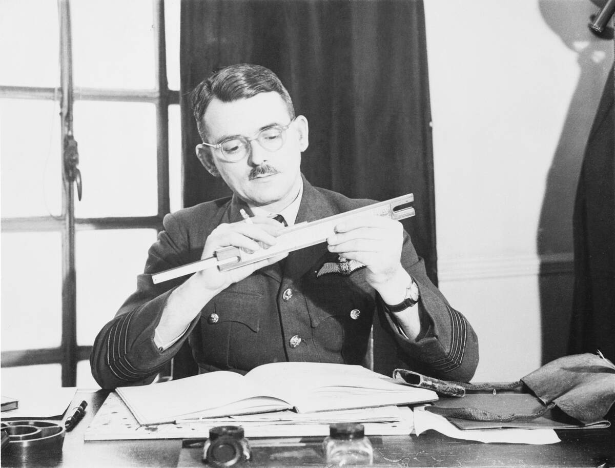 Captain Frank Whittle Using Slide Rule at His Desk