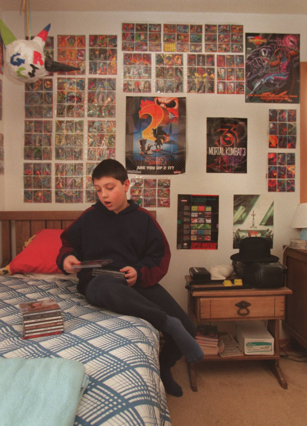 Eleven-year-old Ryan Wagner looks through his collection of country music CD's in his bedroom. On the wall behind him is part of his collection of Magic (?)...I'm checking on this) cards