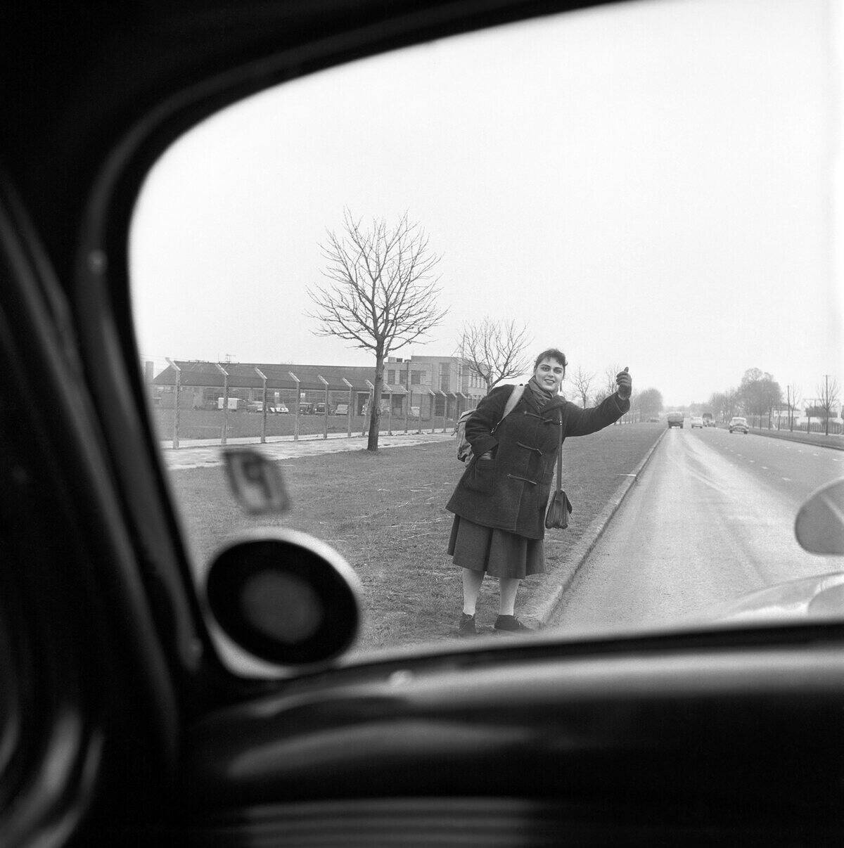 Girl hitch-hiking near Feltham, Middlesex on the A30 road to Southampton, circa 1957